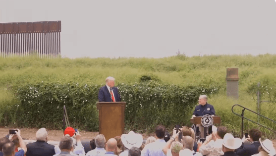 La nota es sobre el aumento histórico de cruces en la frontera México Estados Unidos. La foto es del ex-presidente Donald Trump dando un discurso junto al gobernador de Texas en su última visita a la frontera. 