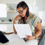 Mujer revisa documentos migratorios antes de decidir si retira su petición VAWA.