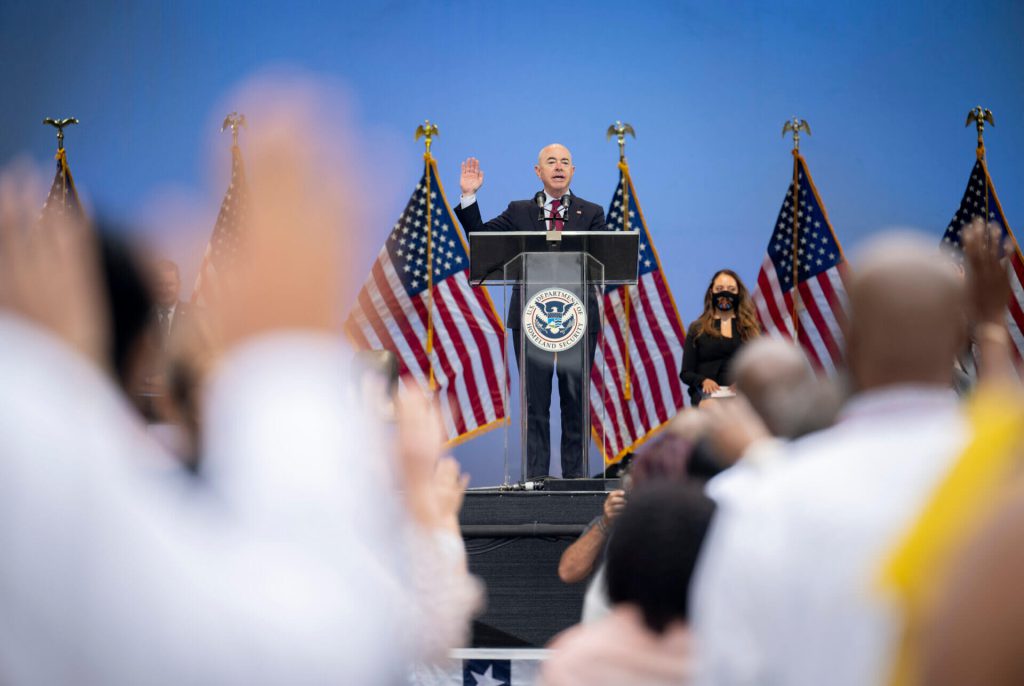 Nota explicando los requisitos para la ciudadanía americana 2021. La foto es de una ceremonia de naturalización realizada recientemente.
